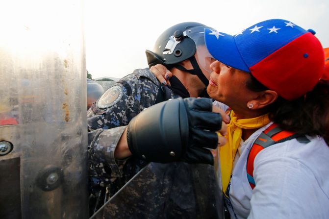 Venezolanos les reclaman a guardias nacionales para exigir que permitan el paso de la ayuda humanitaria en el puente Simón Bolívar.