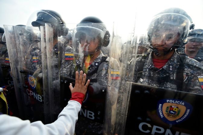 Venezolanos confrontan a policías nacionales para que dejen que la ayuda humanitaria, en el puente Simón Bolívar, en Cúcuta.