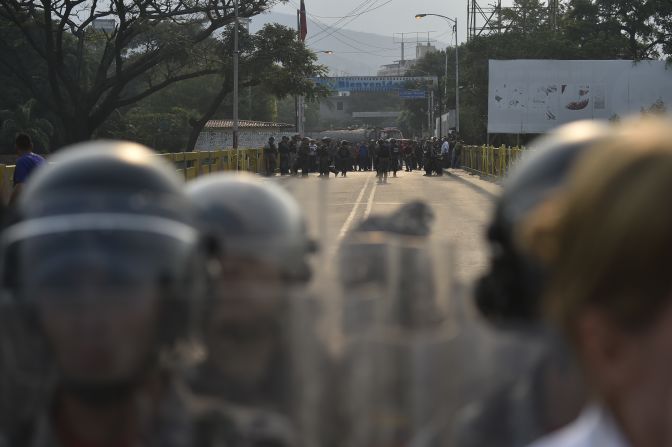 Policías venezolanos hacen un cordón de seguridad frente a ciudadanos venezolanos que piden el ingreso de la ayuda humanitaria en el puente Simón Bolívar,.
