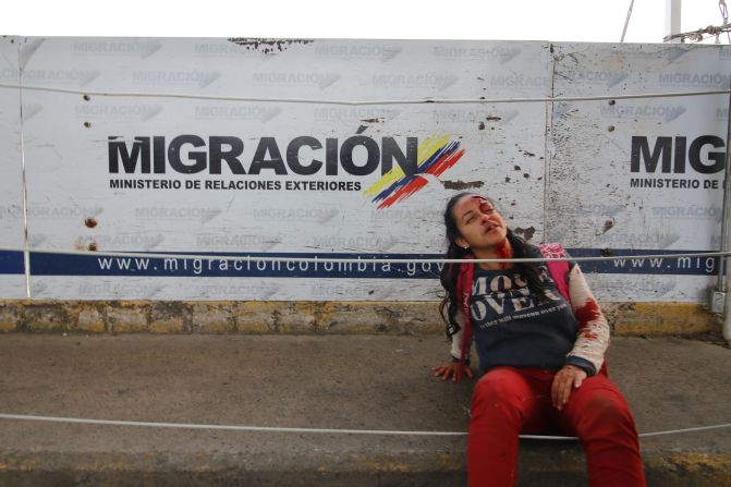 Una mujer se sienta después de quedar herida cuando dos vehículos blindados venezolanos manejaron desde el lado venezolano del Puente Internacional Simón Bolívar hacia Colombia, derribando una valla de seguridad en Cúcuta.