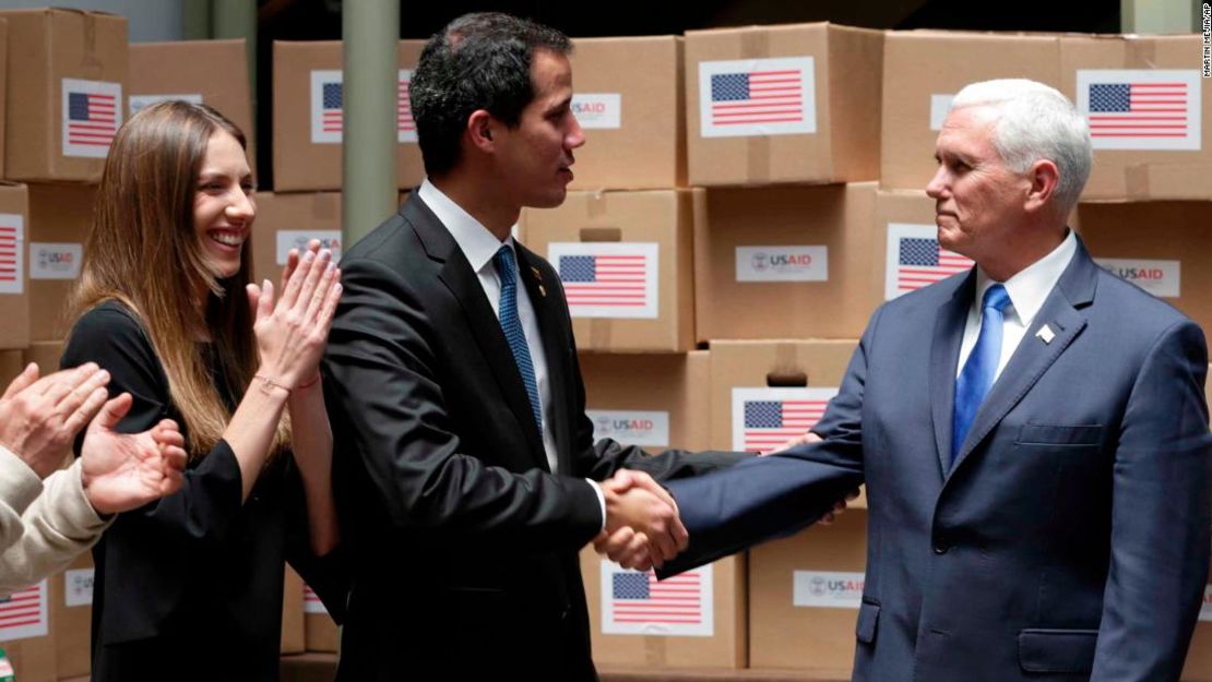 El presidente interino proclamado de Venezuela, Juan Guaidó, le da un apretón de manos al vicepresidente de Estados Unidos, Mike Pence, en un cuarto lleno con ayuda humanitaria destinada para Venezuela en Bogotá, Colombia.