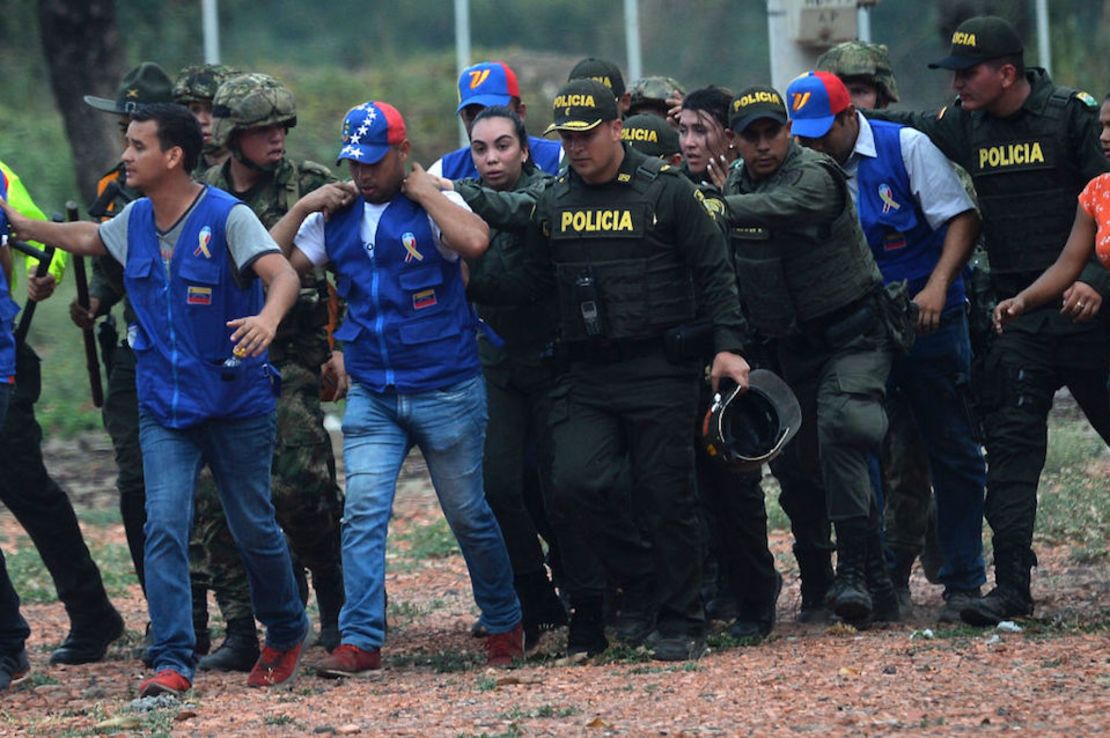 Dos mujeres que dijeron haber desertado de las fuerzas armadas venezolanas son escoltadas por policías colombianos el 23 de febrero cerca del fronterizo puente Simón Bolívar.