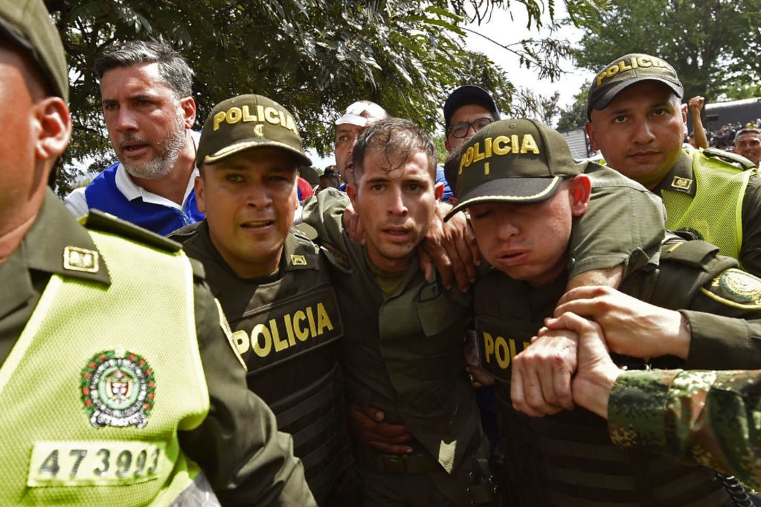 La policía de Colombia acompaña a un policía venezolano que desertó en el Puente Simón Bolivar en Norte de Santander, Colombia, el 23 de febrero de 2019.