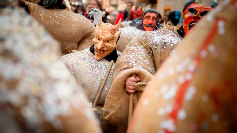 Evolene, Suiza: Hombres vestidos con trajes tradicionales de "hombres de paja" y máscaras de demonios o hechiceros desfilan en su aldea el domingo 3 de marzo. Los hombres de paja representan a los espíritus de los antepasados que se cree que rondan la región.