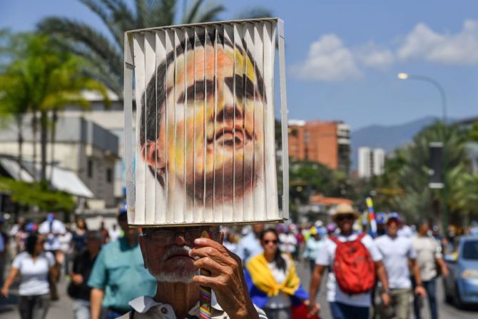 Seguidores de Guaidó en Caracas sostienen un cartel con su rostro el 4 de marzo durante las manifestaciones contra Maduro en la capital venezolana.