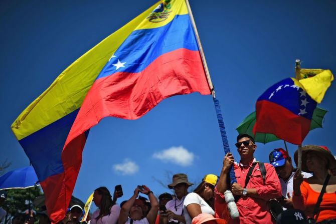 En las calles de Caracas, miles de personas se reúnen con banderas de Venezuela, esperando la llegada de Juan Guaidó, que es reconocido como presidente por 50 países.