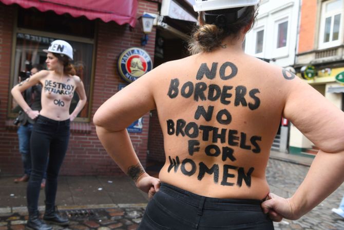 En Berlín, Alemania, las mujeres con el torso descubierto pintaron letreros en sus cuerpos con la frase "Sin fronteras, sin burdeles para las mujeres", en una manifestación en Herbertstrasse, una calle con burdeles reservada solo para hombres en la capital alemana.