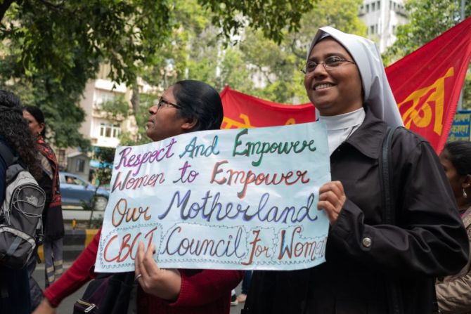 En la India, una mujer sostiene pancartas en la marcha organizada en Nueva Deli que fue organizada por ONGs para protestar contra la violencia doméstica, los ataques sexuales y la discriminación en el trabajo.