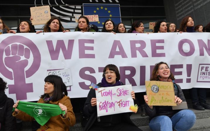 "Estamos en huelga", dicen los carteles de las mujeres que protestaron frente a la sede del Parlamento Europeo en Bélgica este 8 de marzo.