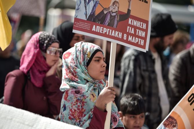 Una niña migrante que hace parte de la marcha de las Mujeres en Atenas, Grecia, por el Día Internacional de la Mujer.