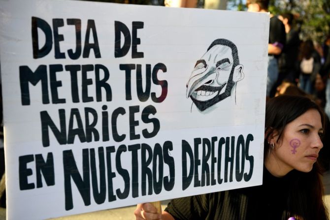 "Deja de meter tus narices en nuestros derechos", dice un cartel en las manifestaciones de Madrid, España, en la que aparece una caricatura del líder del partido de ultraderecha, VOX, Santiago Abascal.