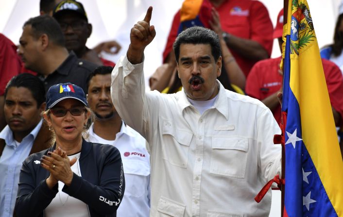 El presidente de Venezuela, Nicolás Maduro, hace un gesto junto a la primera dama Cilia Flores, durante un mitin en el Palacio Presidencial de Miraflores en Caracas. Maduro declaró que un nuevo ataque "cibernético" impidió la reconexión eléctrica, luego de un apagón general.