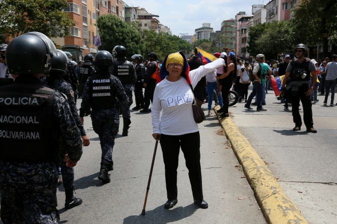 Una mujer que participó en las manifestaciones de Caracas tiene en su camiseta unos carteles que forman la palabra "PAZ".