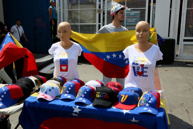 Un hombre vende camisetas y gorras con los colores de la bandera de Venezuela durante una protesta contra el gobierno de Nicolás Maduro.