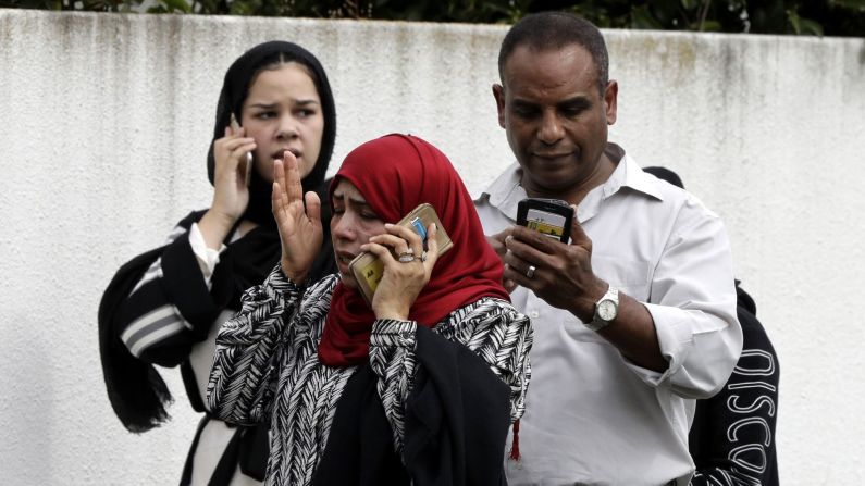 Personas hablan por teléfono afuera de la mezquita.