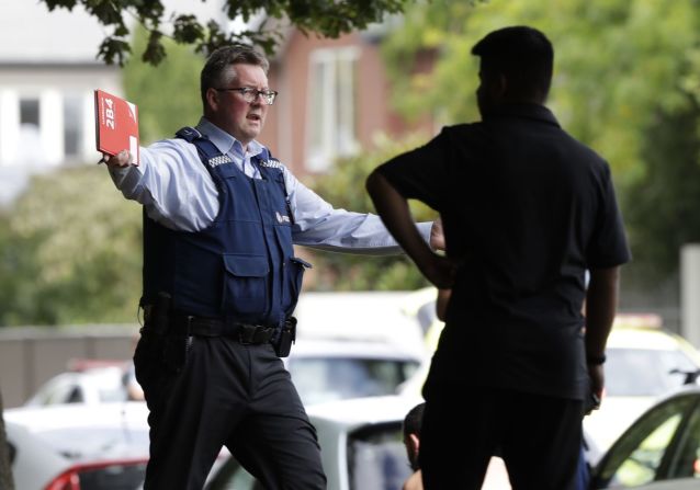Un agente de policía intenta alejar a las personas de una mezquita. (Mark Baker / AP).
