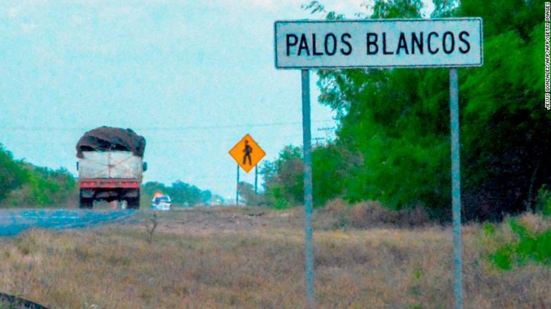 Un camión pasa junto a un letrero en la carretera Reynosa-San Fernando, cerca del lugar donde desaparecieron 19 migrantes.