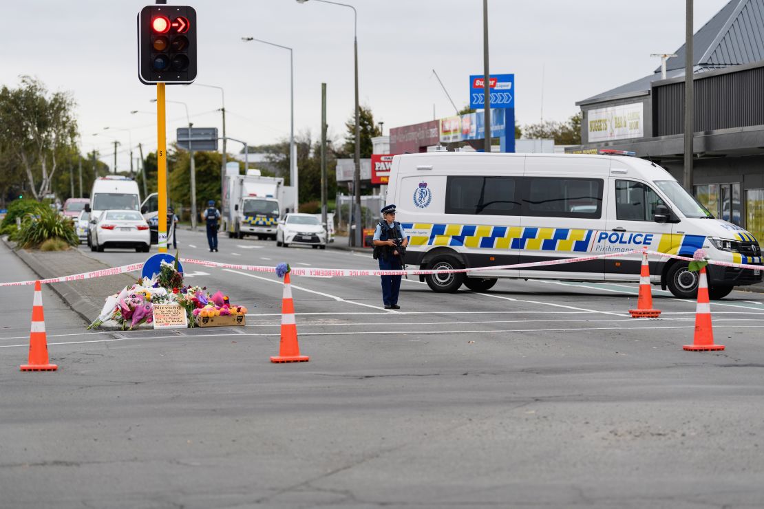 Flores y mensajes de condolencia se aprecian frente a un cordón policial en la avenida Linwood, cerca de la mezquita de Linwood, en ChristChurch, Nueva Zelandia, poco después de los ataques a dos mezquitas, el viernes por la tarde.