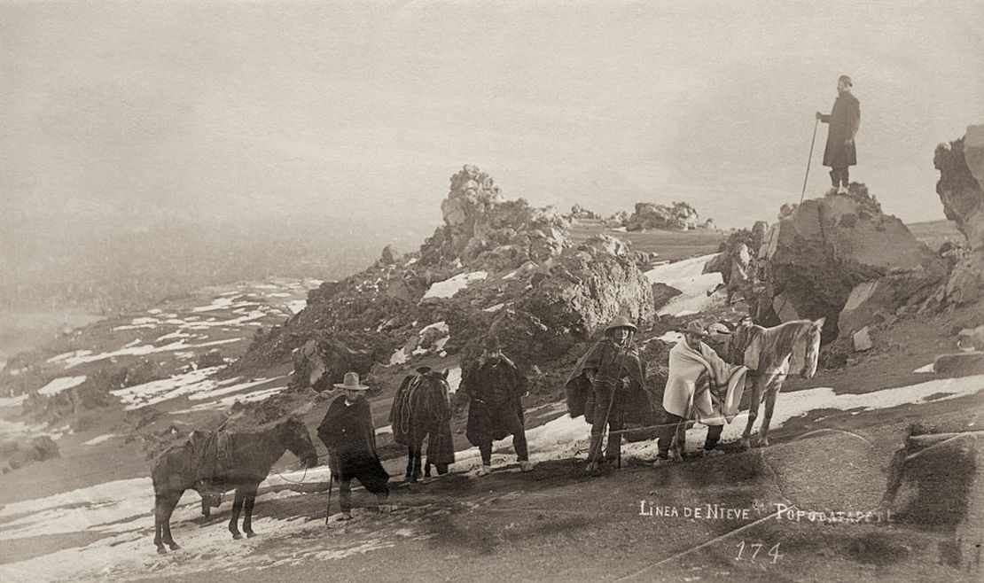 Un grupo de personas ascienden el volcán Popocatépetl con sus caballos cerca del año 1870.