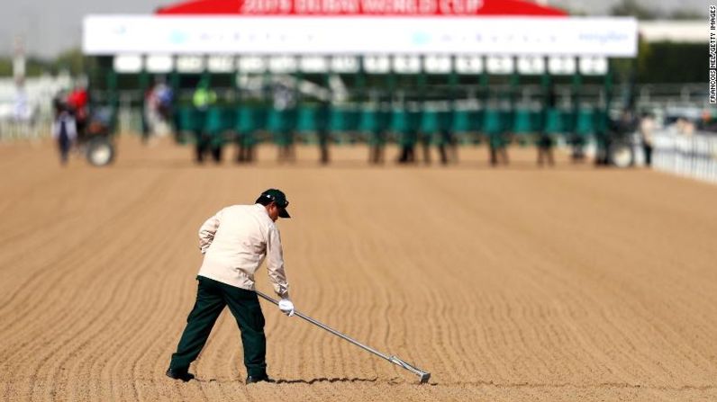 Un jardinero prepara la pista antes de la carrera durante la Copa Mundial Dubai, en el hipódromo de Meydan, el 30 de marzo de 2019.