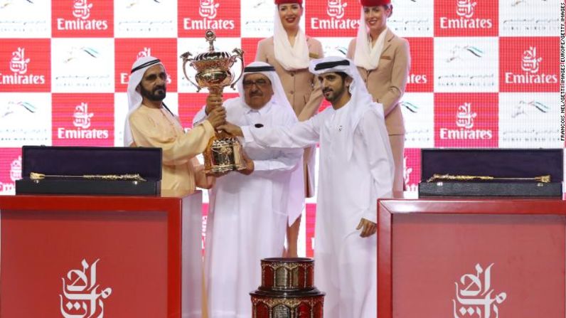 Sheikh Mohammed bin Rashid Al Maktoum (I) recibe el trofeo después de que su caballo Thunder Snow ganara la Copa Mundial de Dubai.