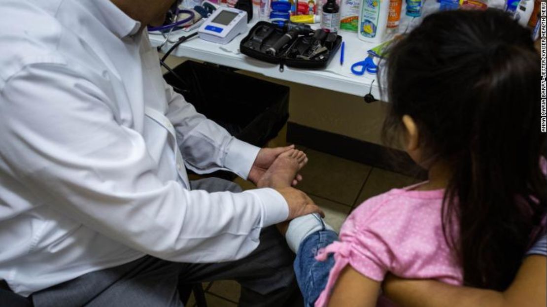 El médico José Manuel de la Rosa examina una erupción en las piernas de Meliza, de 5 años.