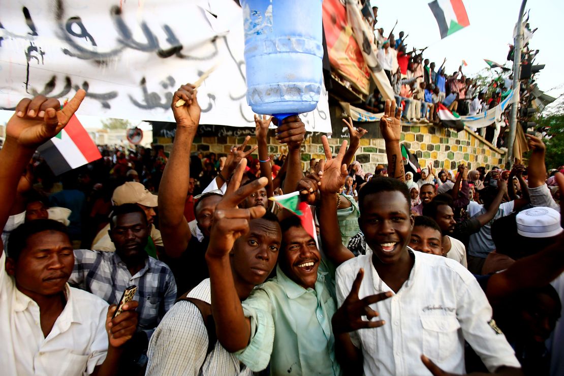 Manifestantes sudaneses lanzan la señal de victoria mientras se reúnen durante una manifestación que exige un cuerpo civil para liderar la transición a la democracia, fuera de la sede del ejército en la capital de Sudán, Jartum.