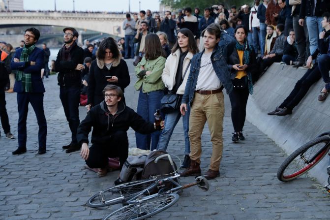 Un grupo de personas observa el incendio en la histórica catedral de Notre-Dame en el centro de París el 15 de abril de 2019. Crédito: THOMAS SAMSON / AFP / Getty Images