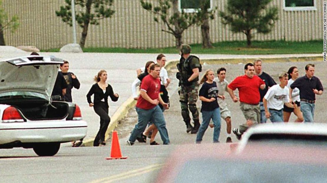 Estudiantes de la escuela secundaria Columbine corren protegidos por la policía el 20 de abril de 1999.