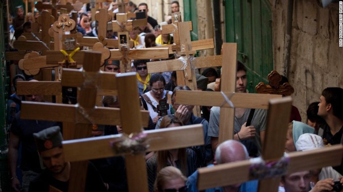 Cristianos Ortodoxos peregrinan sosteniendo cruces de madera mientras participan en la procesión del Viernes Santo a través de la Vía Dolorosa en Jerusalén.