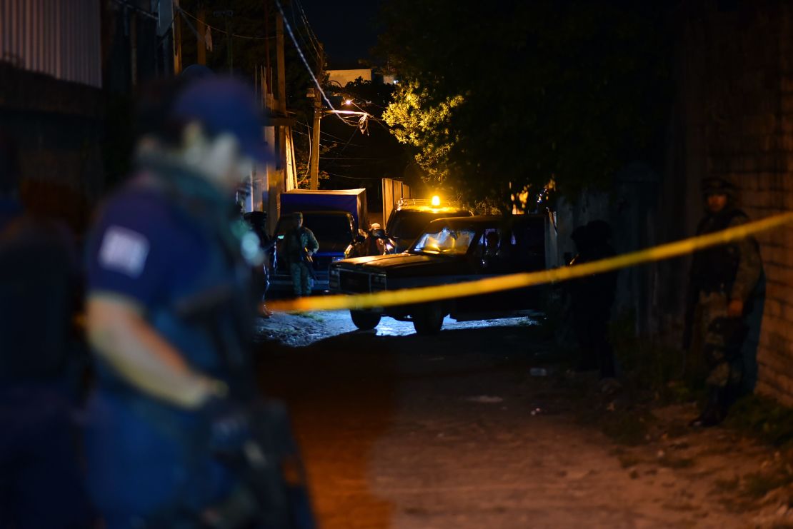 Miembros de la policía municipal de Minatitlán montan guardia fuera del lugar donde murieron 13 personas en el tiroteo ocurrido durante una fiesta en Minatitlán, estado de Veracruz, México.