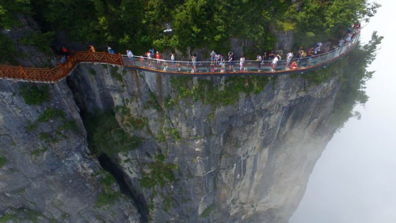 Parque Nacional Forestal de Zhangjiajie, China — Conocido por sus imponentes pilares de arenisca, este bosque se explora mejor a pie. Los visitantes pueden experimentar vistas espectaculares en la pasarela de vidrio de 100 metros de largo y 1.6 metros de ancho que se aferra al acantilado de la montaña Tianmen. (VCG / Getty Images).