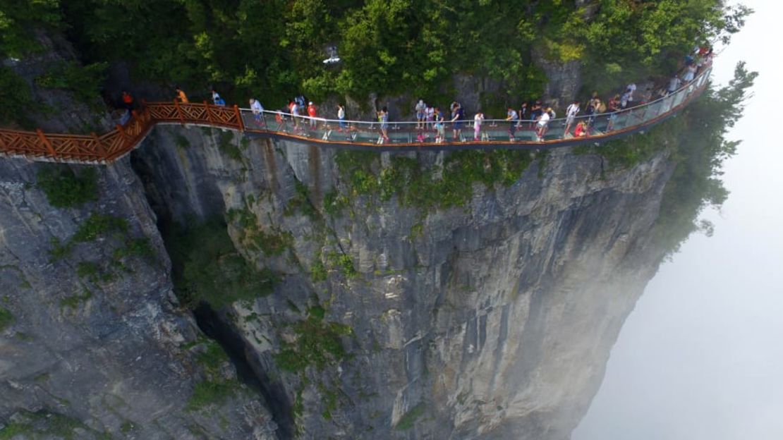 Parque Nacional Forestal de Zhangjiajie, China — Conocido por sus imponentes pilares de arenisca, este bosque se explora mejor a pie. Los visitantes pueden experimentar vistas espectaculares en la pasarela de vidrio de 100 metros de largo y 1.6 metros de ancho que se aferra al acantilado de la montaña Tianmen. (VCG / Getty Images).