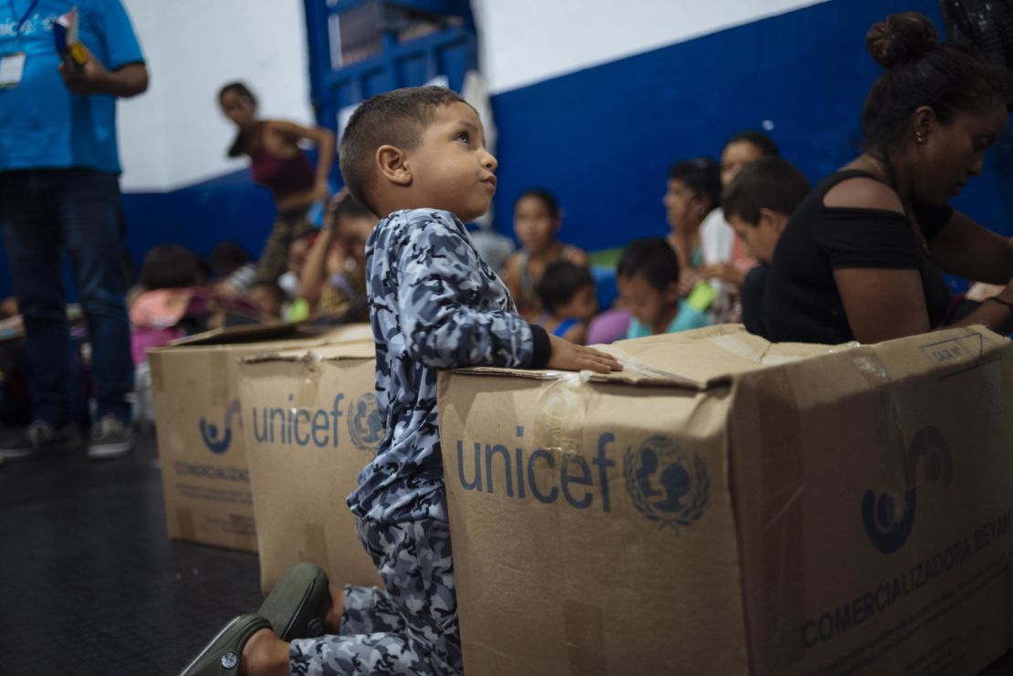 Niños juegan entre las cajas de ayuda en un centro de atención en Cúcuta.