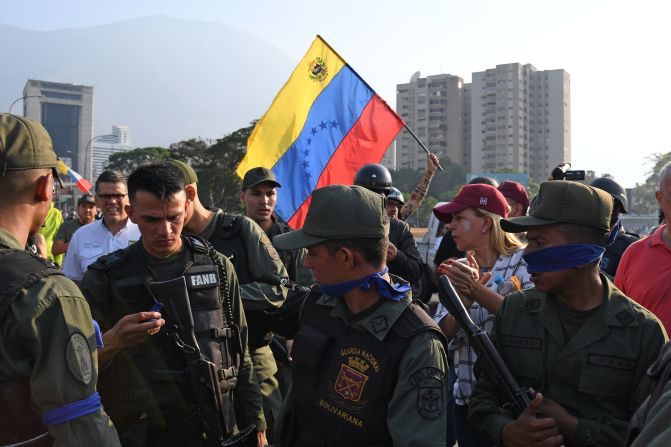 Un grupo de personas junto a miembros de las fuerzas de seguridad en Caracas el 30 de abril de 2019. Crédito: YURI CORTEZ / AFP / Getty Images