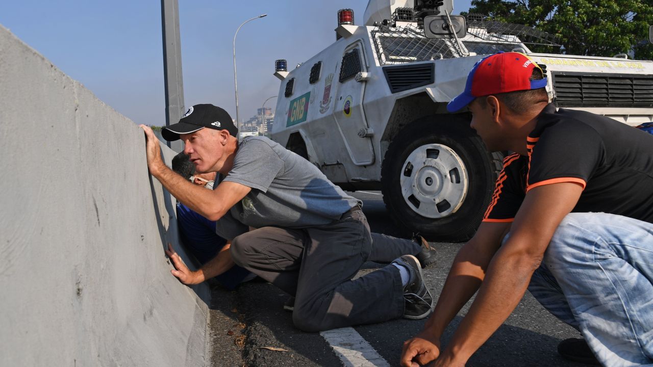 Venezolanos se protegen durante los enfrentamientos con las fuerzas de seguridad en Caracas el 30 de abril de 2019. Crédito: YURI CORTEZ / AFP / Getty Images