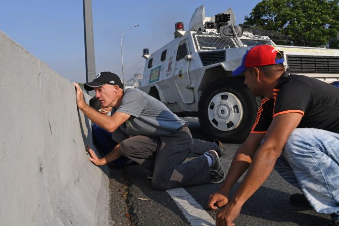 Venezolanos se protegen durante los enfrentamientos con las fuerzas de seguridad en Caracas el 30 de abril de 2019. Crédito: YURI CORTEZ / AFP / Getty Images