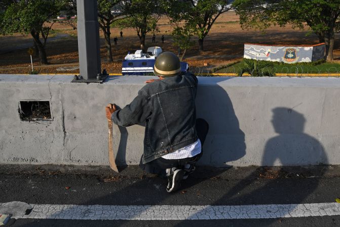 Un hombre mira a los miembros de las fuerzas de seguridad en Caracas el 30 de abril de 2019. Crédito: YURI CORTEZ / AFP / Getty Images