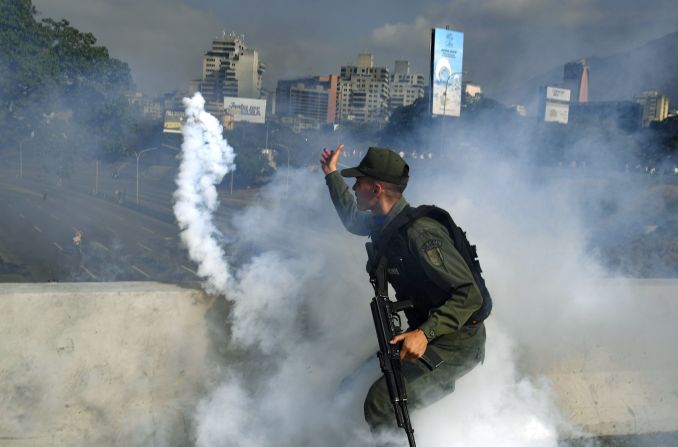 Un miembro de la Guardia Nacional Bolivariana que apoya a Juan Guaidó lanza un bote de gas lacrimógeno durante un enfrentamiento con guardias leales al gobierno del presidente Nicolás Maduro frente a la base militar de La Carlota en Caracas el 30 de abril de 2019. Crédito: YURI CORTEZ / AFP / Getty Images