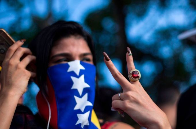 REPÚBLICA DOMINICANA. Una mujer hace la señal de la victoria durante una protesta contra Maduro en Santo Domingo.