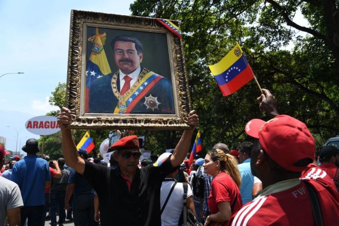 Simpatizantes del president Maduro muestran un retrato del mandatario durante las protestas.