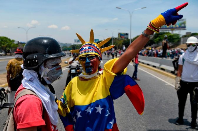 Anti-government protesters take part in a march in Caracas to commemorate May Day on May 1, 2019 after a day of violent clashes on the streets of the capital spurred by Venezuela's opposition leader Juan Guaido's call on the military to rise up against President Nicolas Maduro. - Guaido called for a massive May Day protest to increase the pressure on President Maduro. (Photo by Matias Delacroix / AFP).