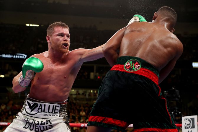 "Canelo" Alvarez golpea a Daniel Jacobs durante su pelea de unificación de títulos.