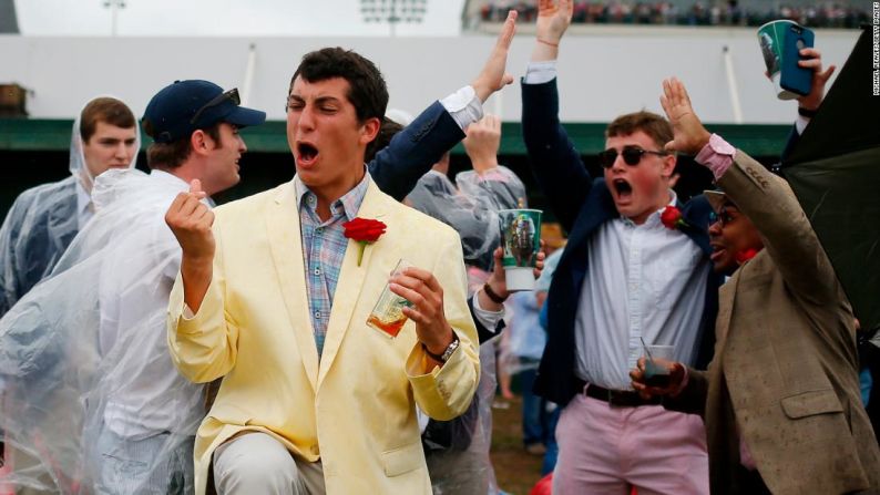 Los fanáticos reaccionan a una de las carreras antes del Derby de Kentucky en Churchill Downs.