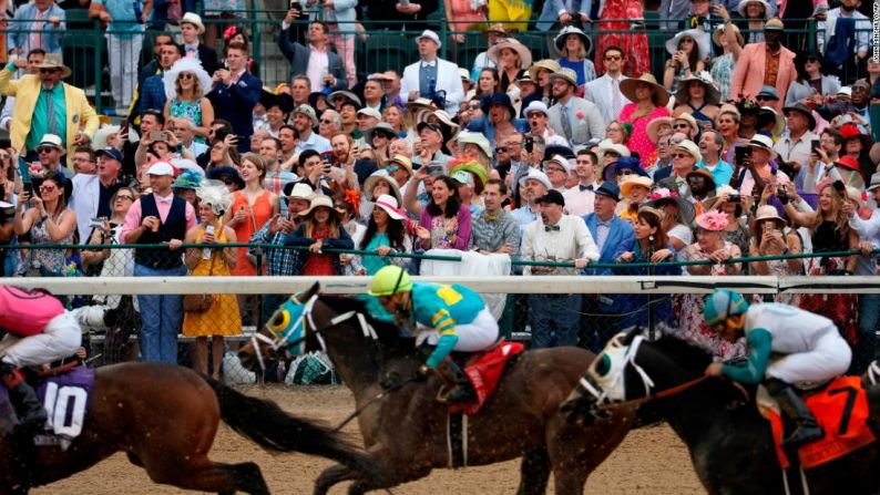 La gente aplaude mientras presencian en Churchill Downs la edición 145 del Derby de Kentucky.