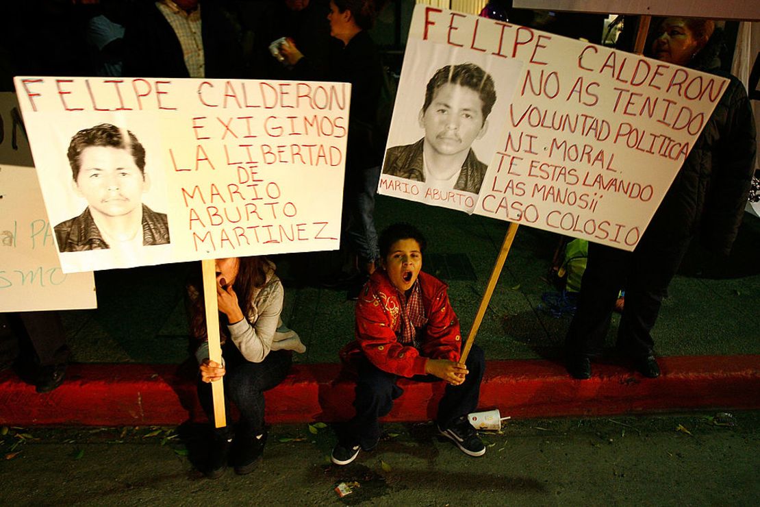 Manifestantes sostienen pancartas con la foto de Mario Aburto Martínez durante una manfiestación contra el presdiente Felipe Calderón que estaba de visita en Los Ángeles, el 13 de febrero de 2008.