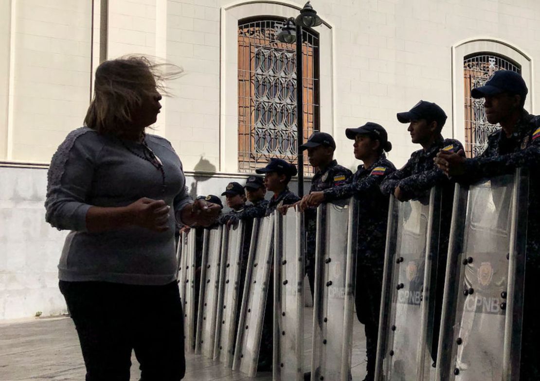 Una mujer protesta frente a elementos de la Policía Nacional Bolivariana que resguardan los alrededores del parlamento.