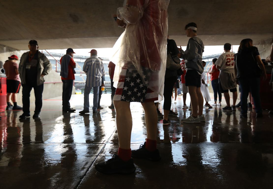 Los asistentes esperan durante una demora por lluvia antes del partido entre los Cardenales de San Luis y los Rangers de Texas en el Globe Life Park, en Arlington, Texas.