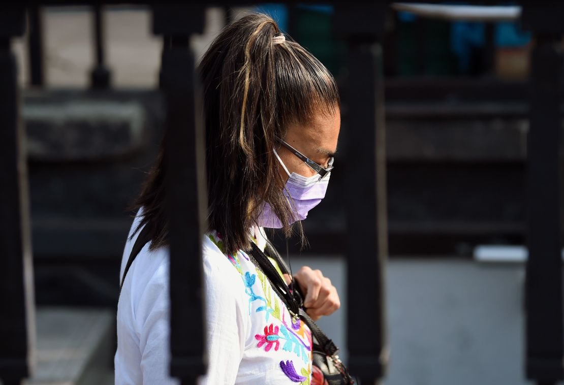 Una mujer usa una mascarilla para protegerse de la contaminación en Ciudad de México.