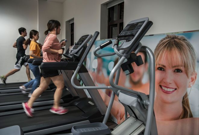 Empleados de Huawei usan caminadoras en un gimnasio de la empresa después del trabajo.